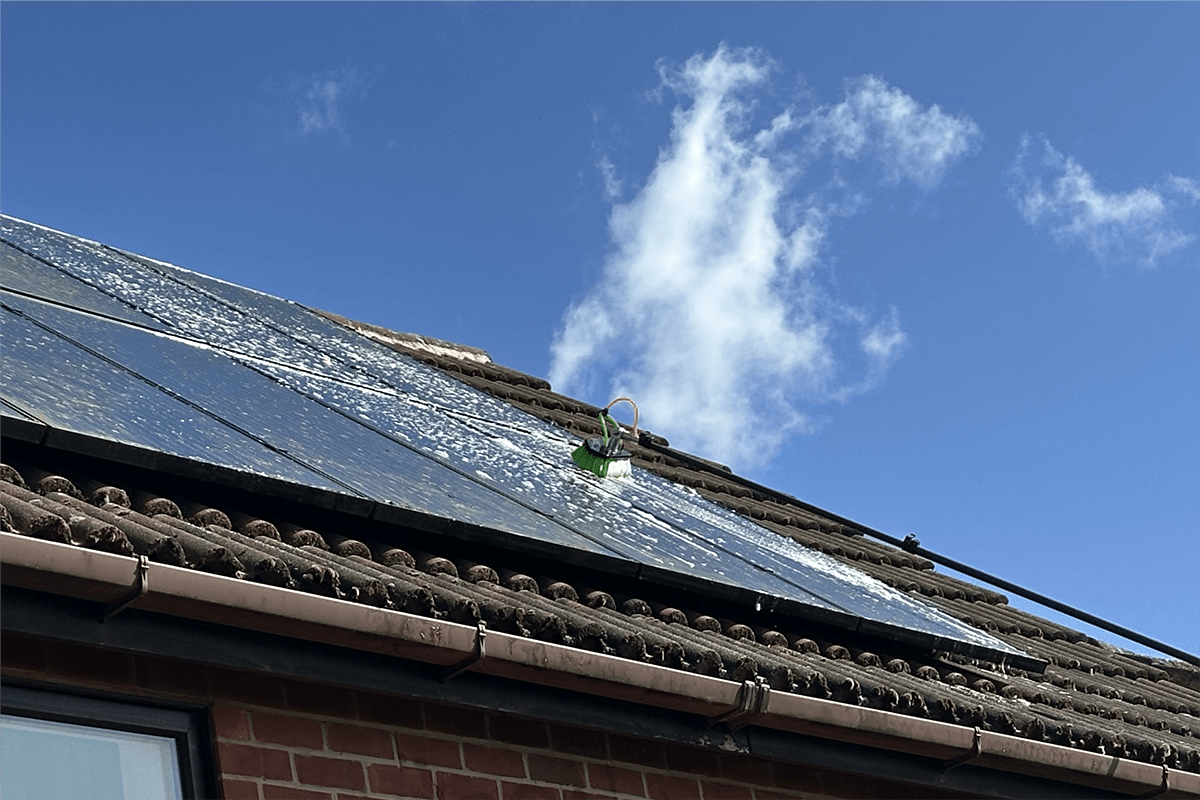 Solar panels being cleaned on a roof
